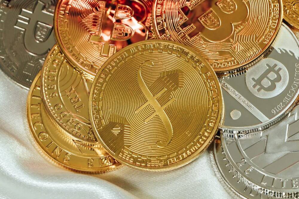 Coins representing bitcoin, litecoin and filecoin.