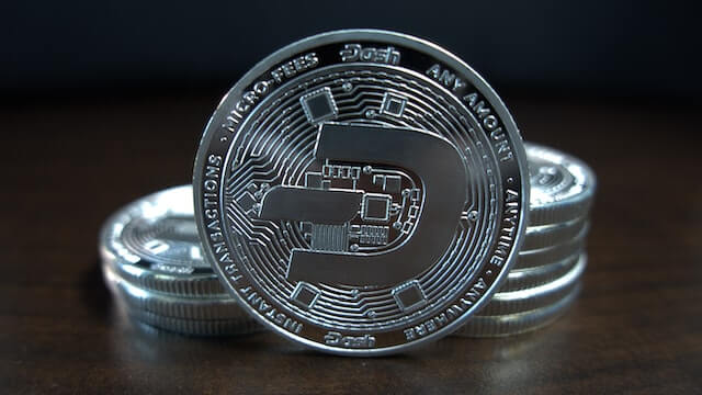 Dash cryptocurrency, represented by a physical silver coin. 