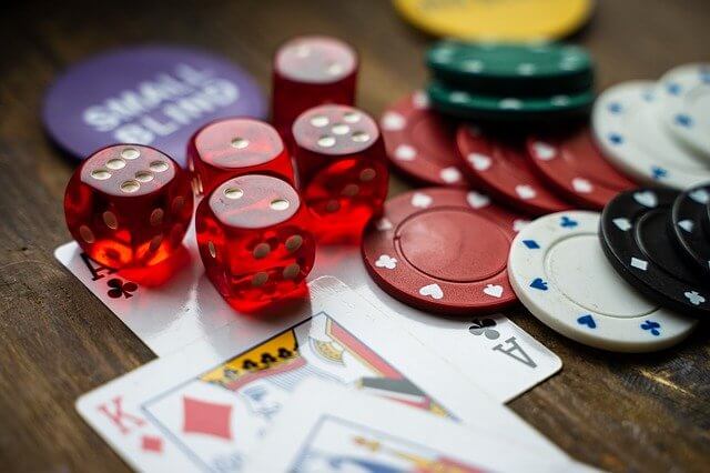 Playing cards, dice and casino chips on a table.