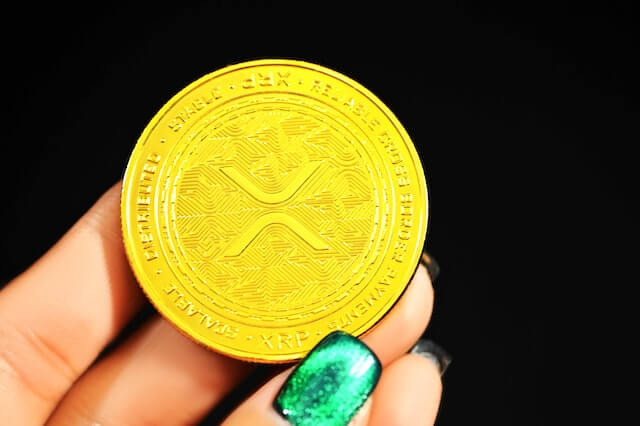 XRP cryptocurrency, represented by physical coin, being held in hand. 
