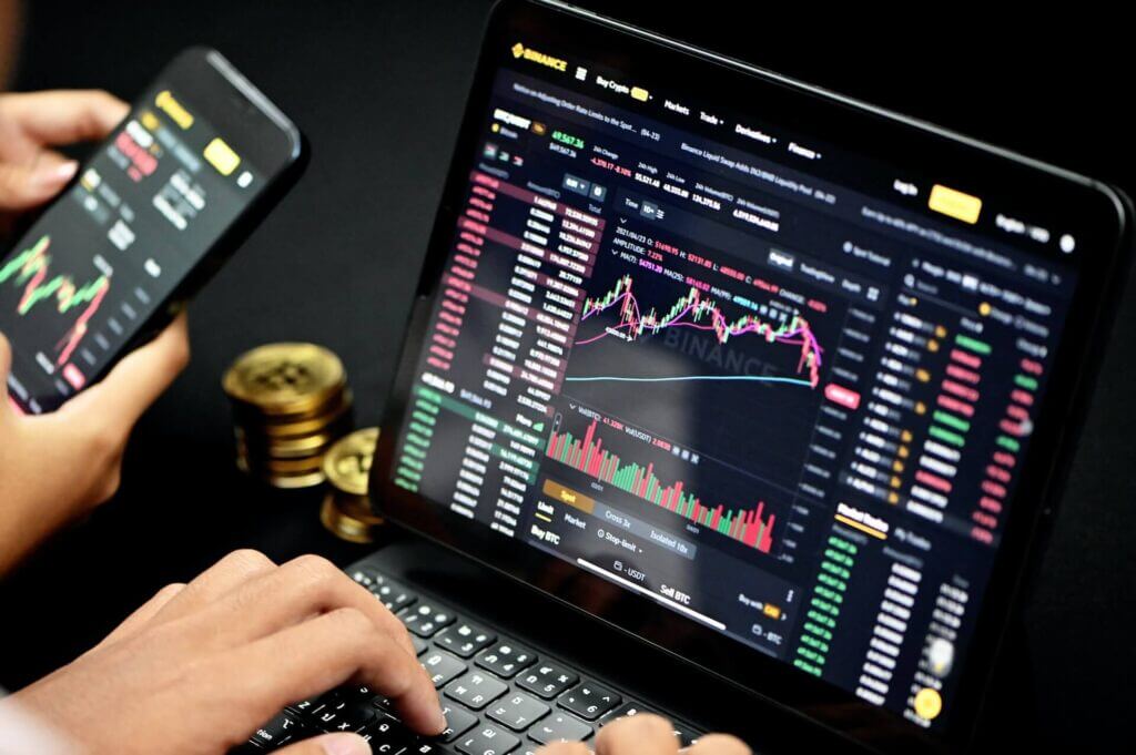 Binance crypto exchange trading being used on a laptop and smartphone
