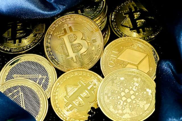 Various cryptocurrencies, including Bitcoin, ADA and NEO, represented by physical coins.