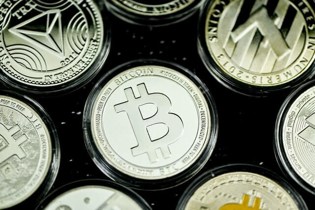 Various cryptocurrencies, including Bitcoin and Litecoin, represented by physical coins.