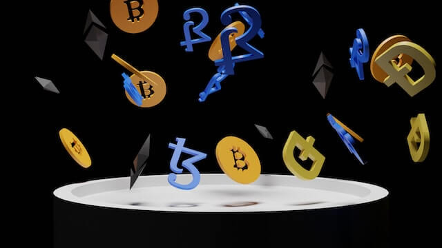 Various cryptocurrencies, represented by their symbols, falling onto a tray. 
